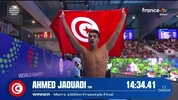 Capture d'écran de Ahmed Jaouadi qui célèbre son titre sur le 1500m avec le drapeau tunisien au bord de la piscine